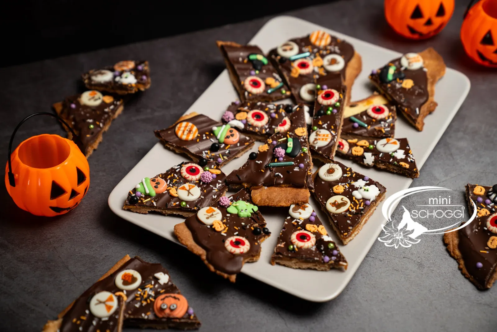 Teller mit Halloween-Bruchschokolade und Kürbislaternen