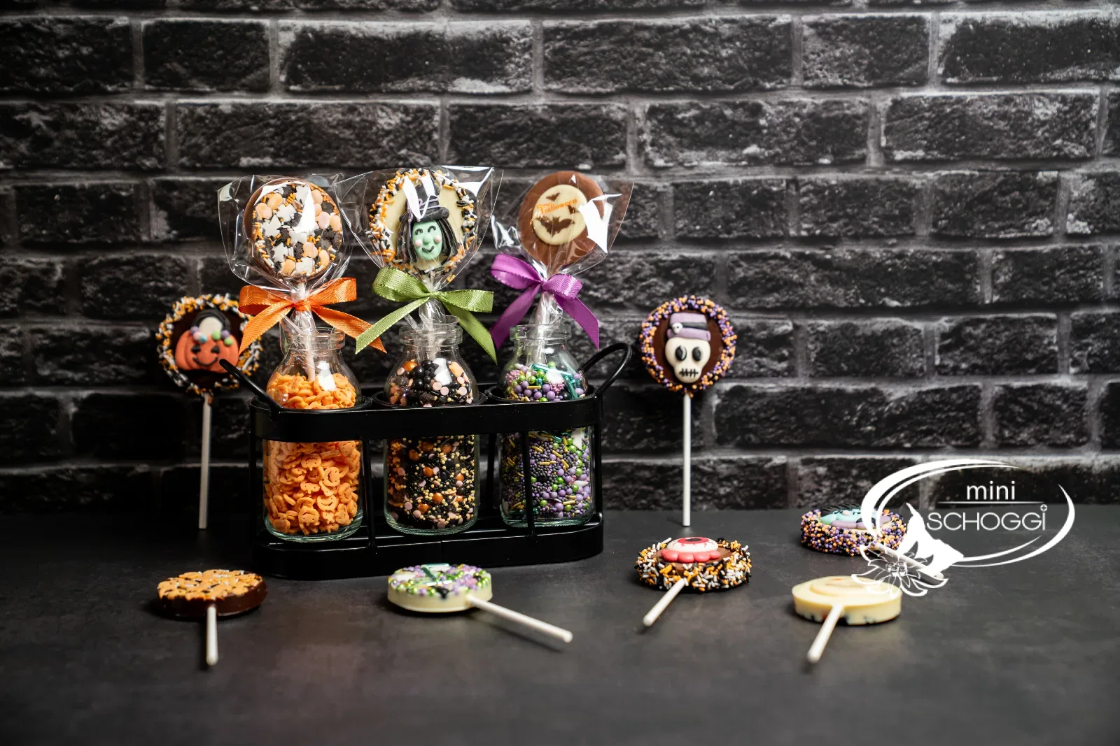 Halloween-Lollipops in einer Reihe auf dunklem Grund