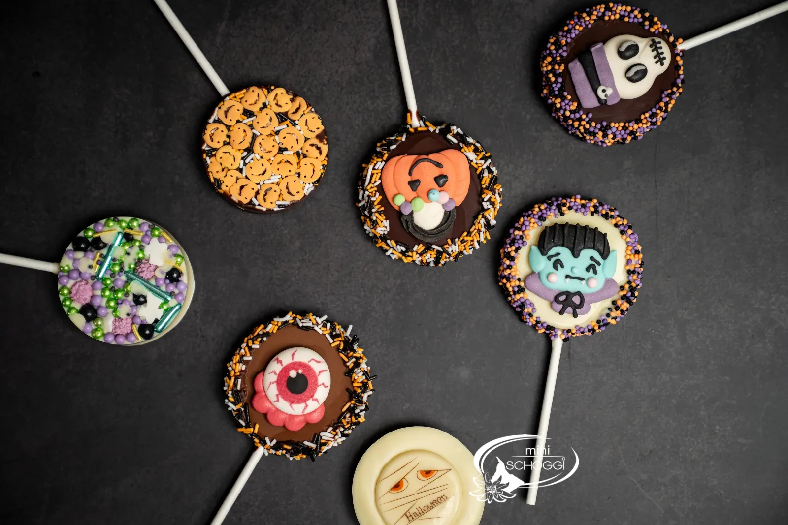Drei verpackte Lollipops als Geschenk vor einer Backsteinwand