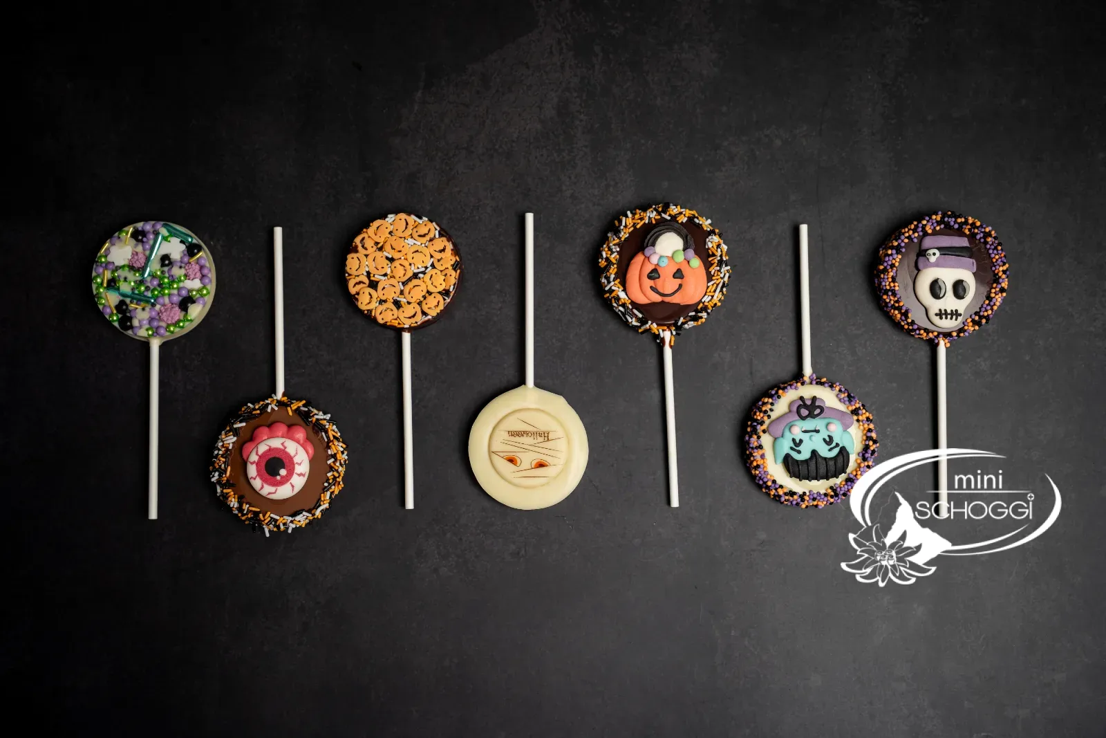 Halloween-Lollipops als Tischdeko vor einer Backsteinwand