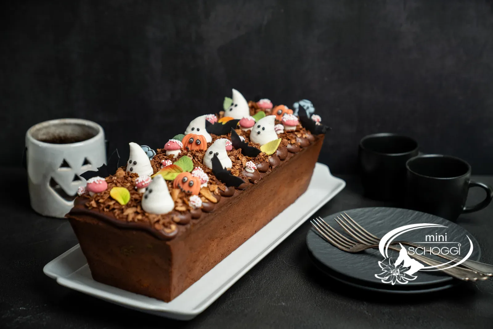 Ganzer Halloween-Marmorkuchen mit Deko auf weisser Platte
