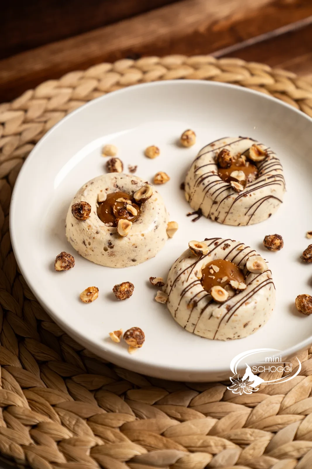 Zwei Teller mit Haselnuss-Karamell-Parfait, angerichtet mit Karamell und Nüssen