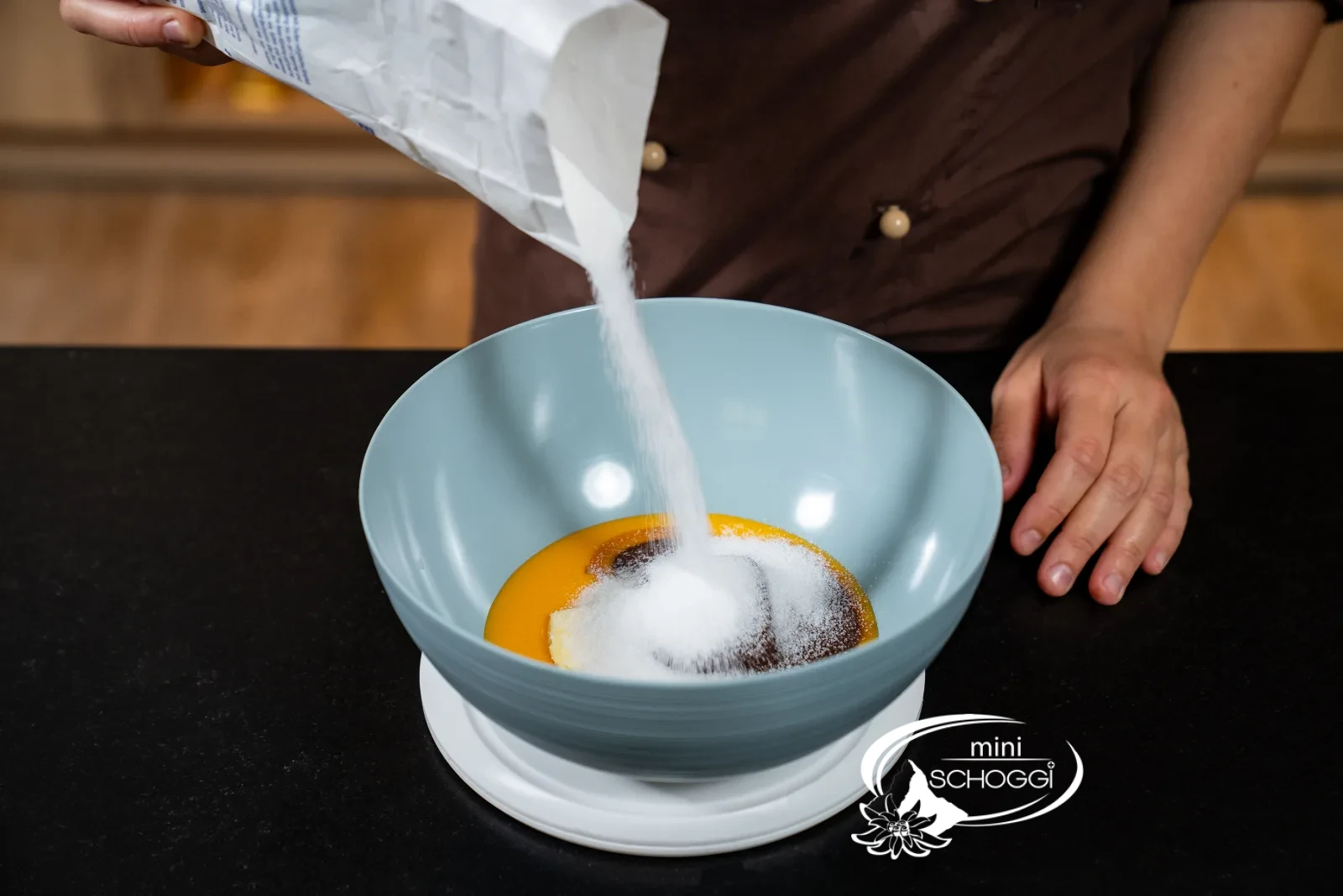 Le sucre cristallisé est pesé avec les jaunes d'œufs, le beurre et la couverture fondue