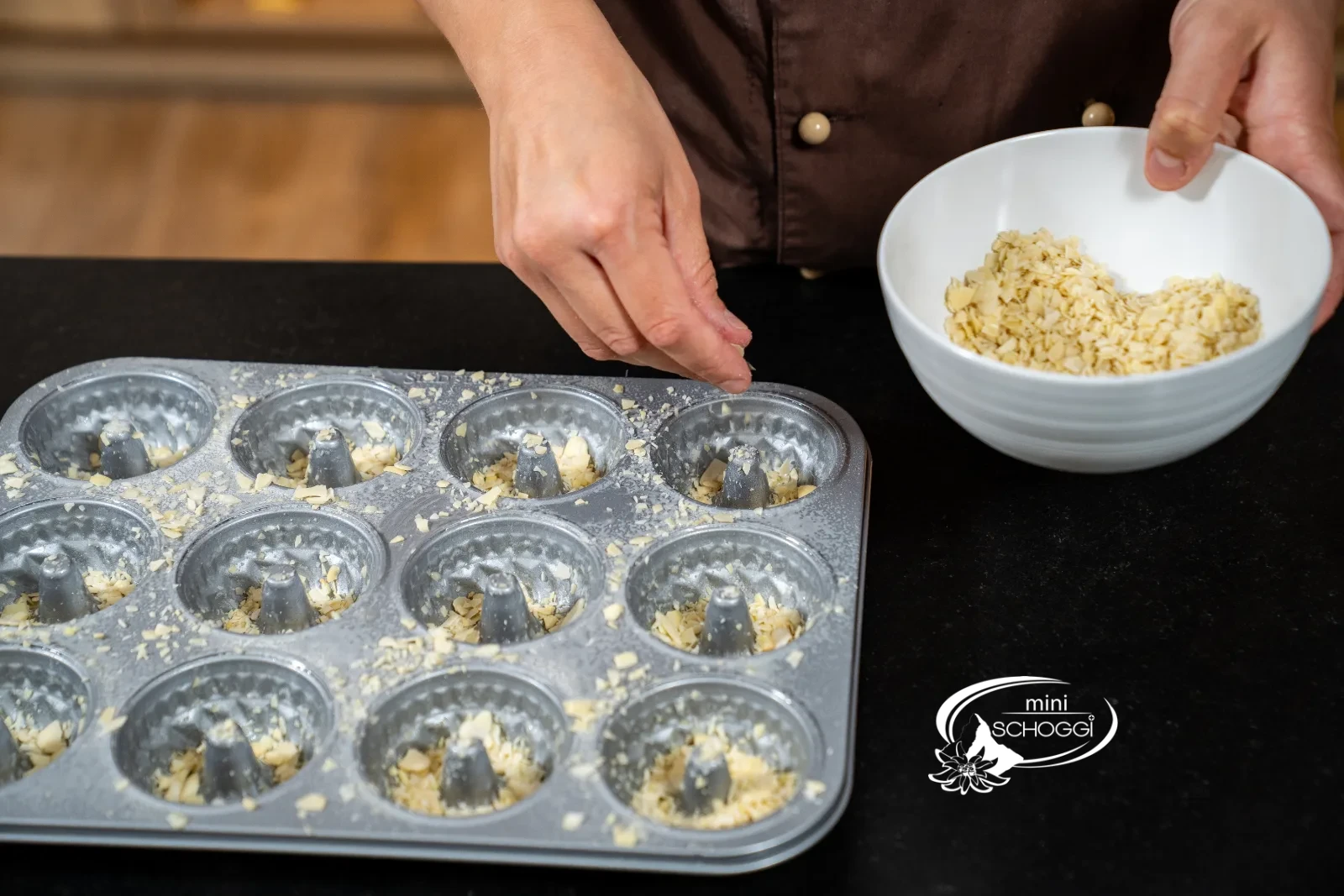 Des éclats d'amandes concassées sont parsemés dans les alvéoles beurrées
