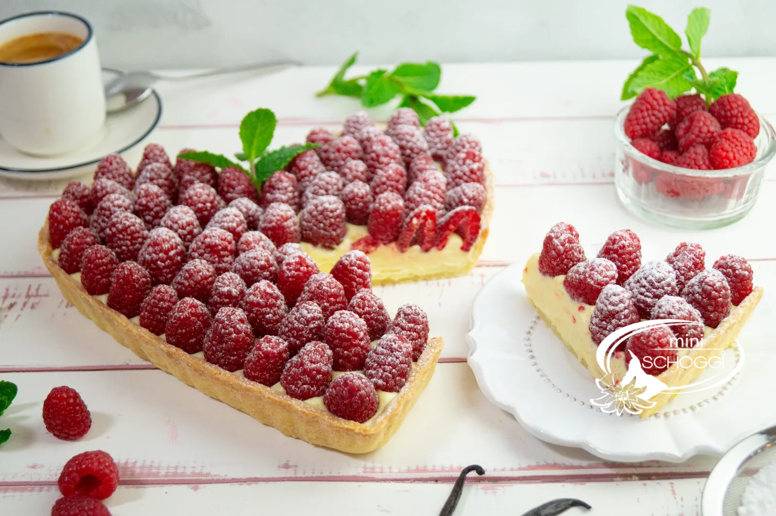 Herztorte mit Vanillecreme und frischen Himbeeren, mit Puderzucker bestäubt