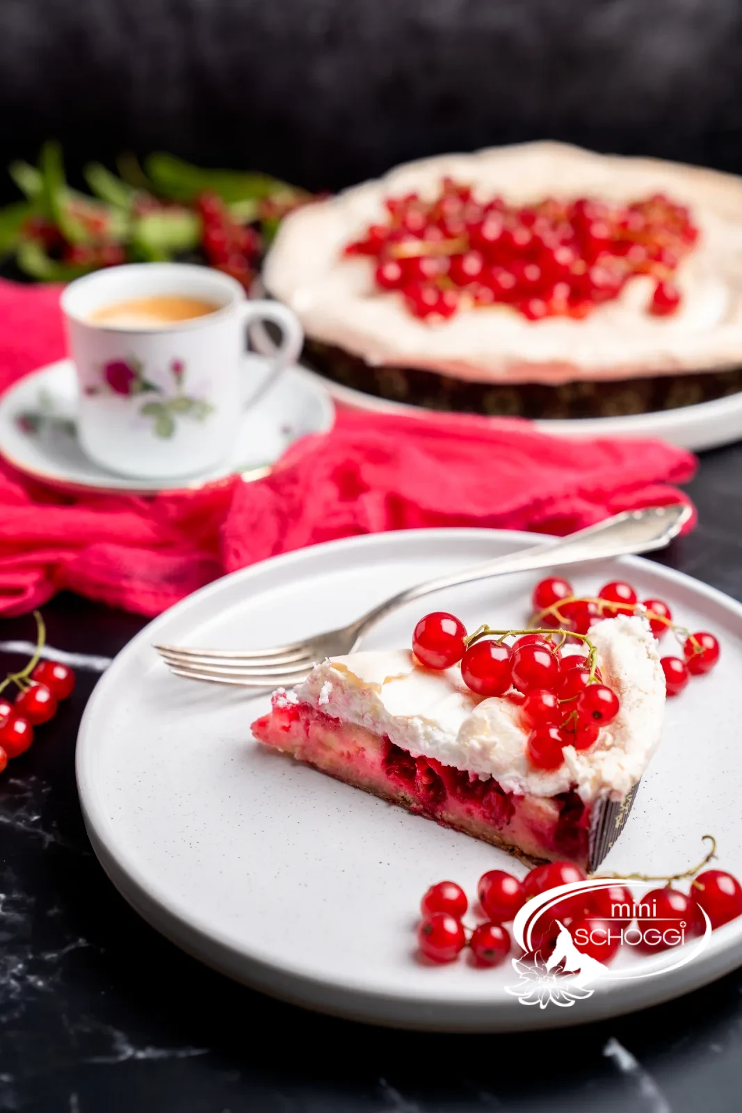 Fetta di torta con strati di base, ribes e meringa su un piatto bianco