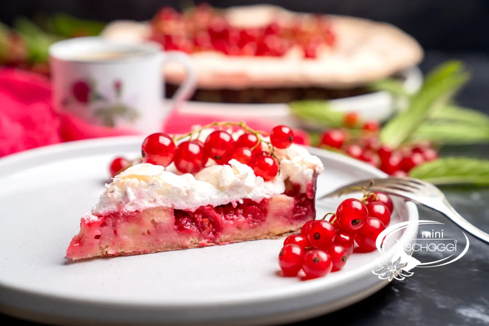 Fetta di torta con strati di base, ribes e meringa su un piatto bianco