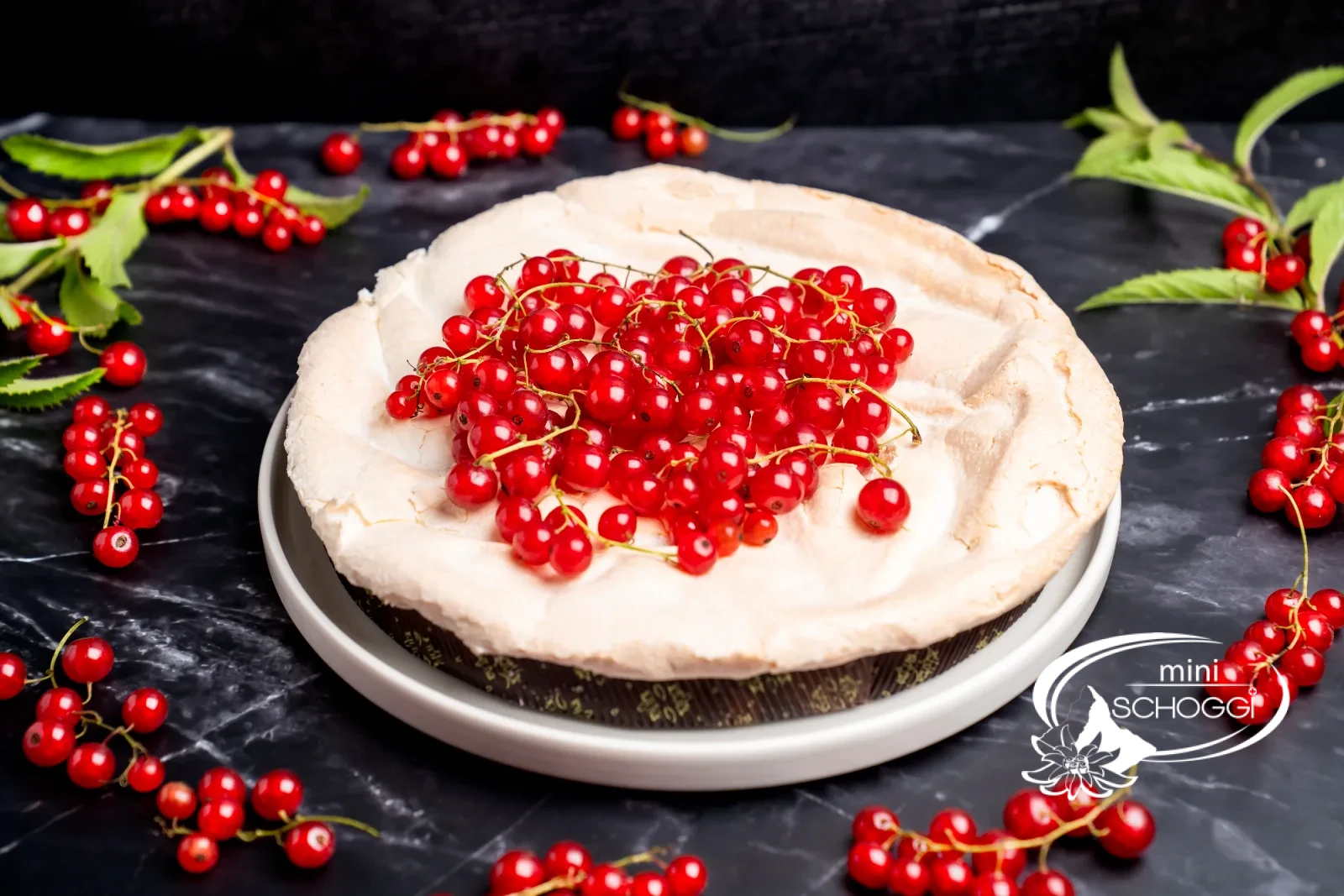 Un boccone di torta con ribes e meringa, sullo sfondo la fetta di torta
