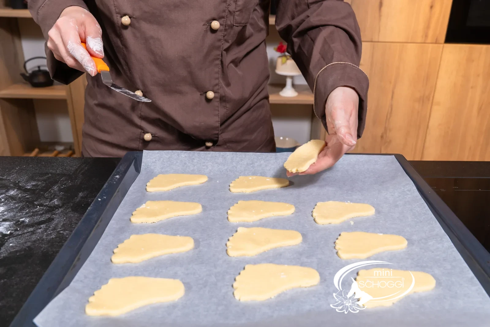I piedini medi vengono sollevati con cura sulla carta da forno con la palette