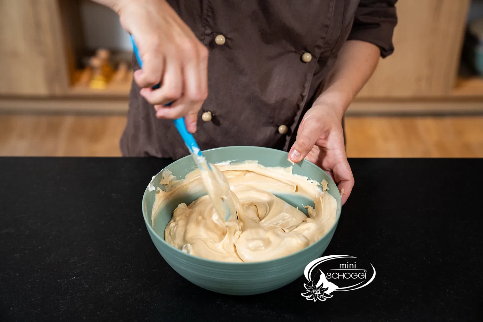 Der Rahm wird mit dem Gummischaber unter die Karamellcreme gehoben
