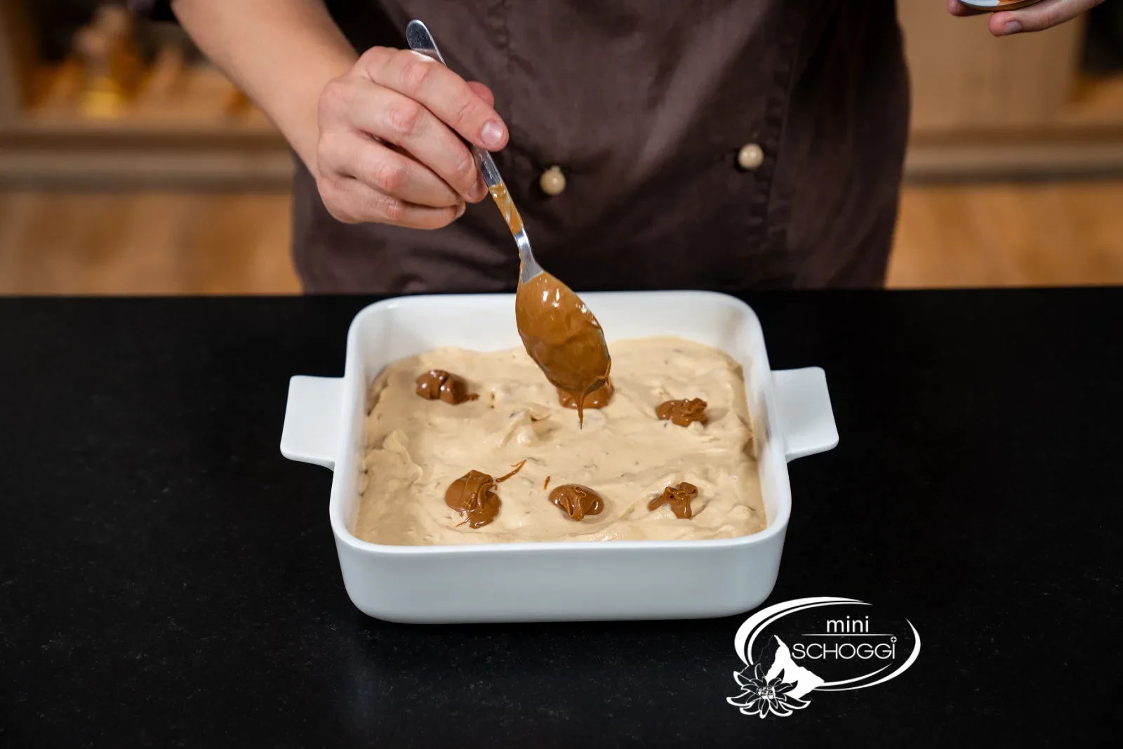 Mit dem Löffel werden Punkte aus Karamellcreme aufgesetzt