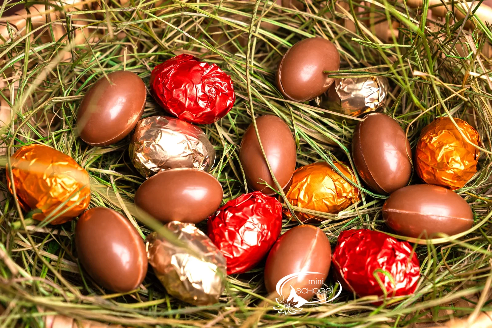 Un kinder schoko bons croqué révèle la ganache claire à la noisette, derrière le coquetier avec de petits œufs colorés