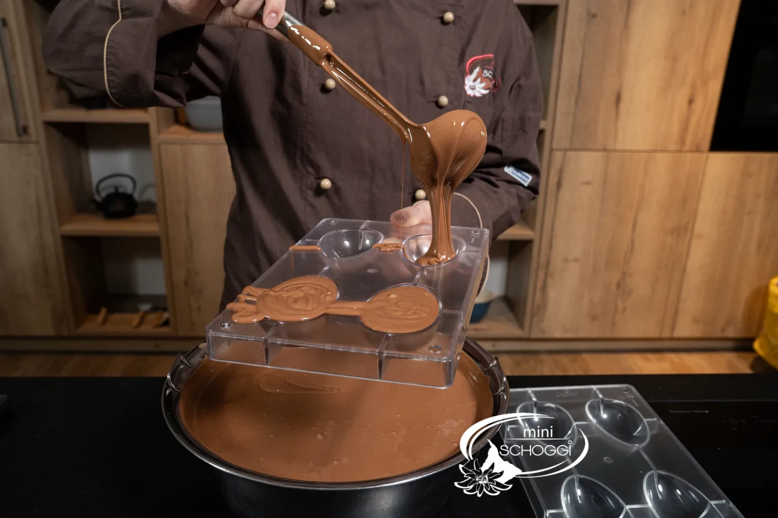 The tempered milk couverture is poured into the egg mold