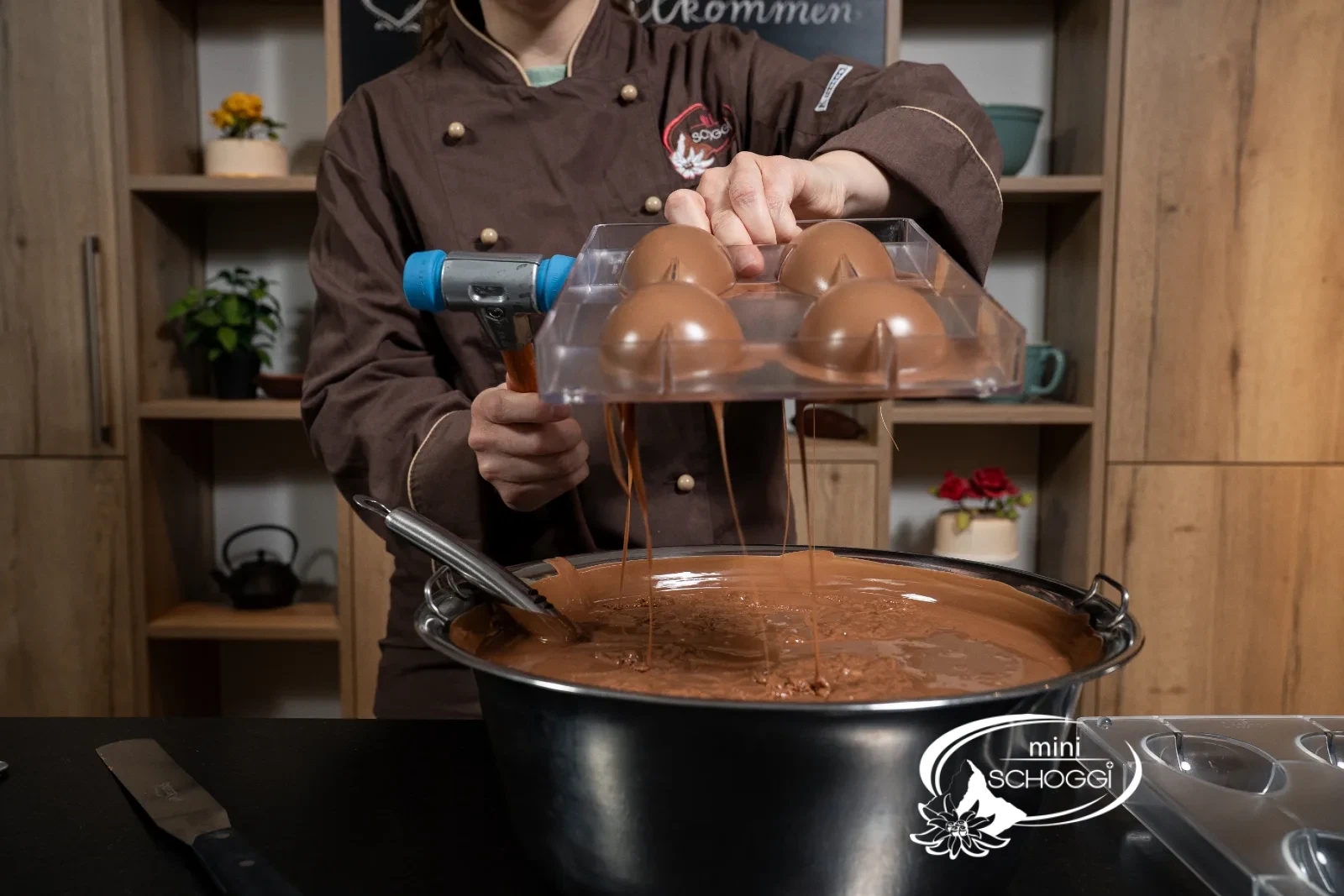 The excess milk couverture flows back into the tempering device