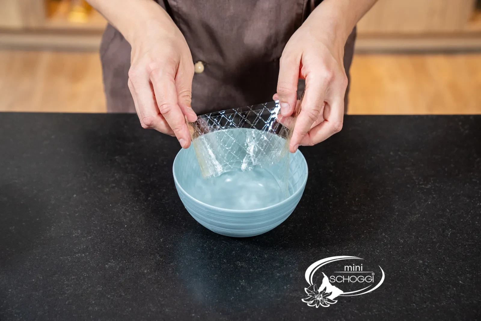 Zucker-Eiweiss-Masse mit Gelatine wird in einer Schüssel über dem Wasserbad gerührt, daneben ein digitales Thermometer