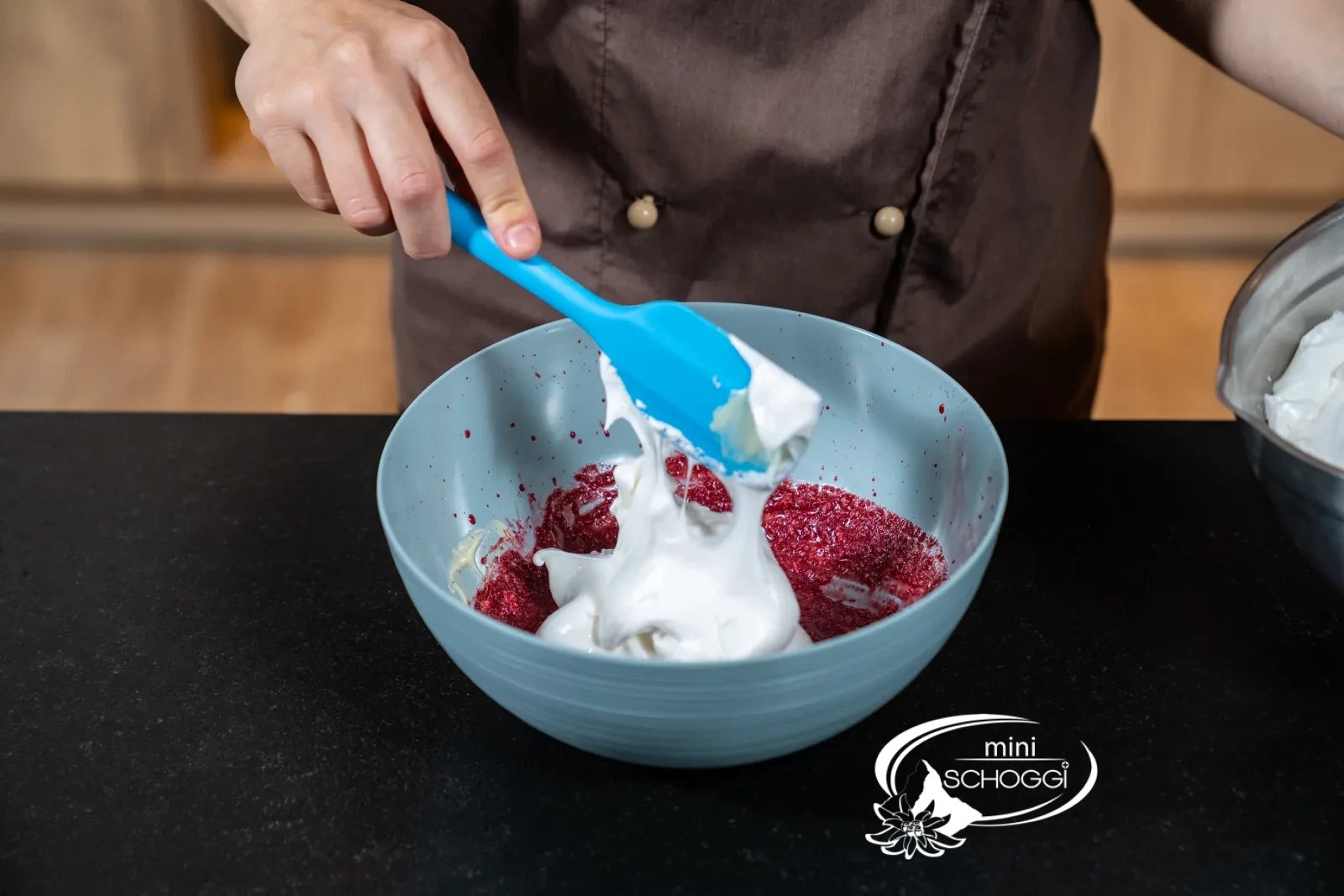 osa Mousse wird mit dem Spritzsack in die Mulden einer Silikonform in Kirschenform gefüllt