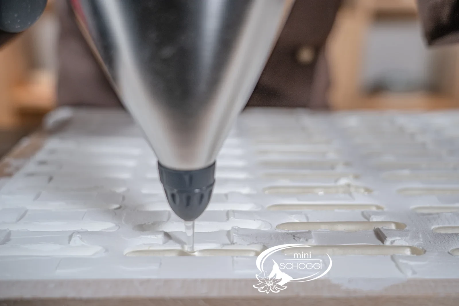 Con l'imbuto professionale lo sciroppo di kirsch viene versato negli stampi timbrati