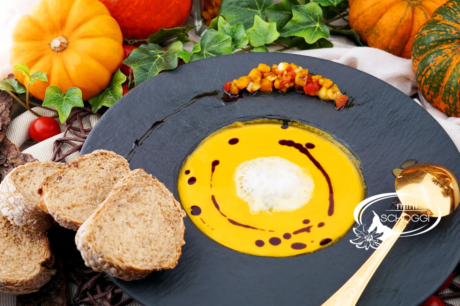 Piatto di cremosa zuppa di zucca con schiuma di latte, olio di semi di zucca e Hüppen