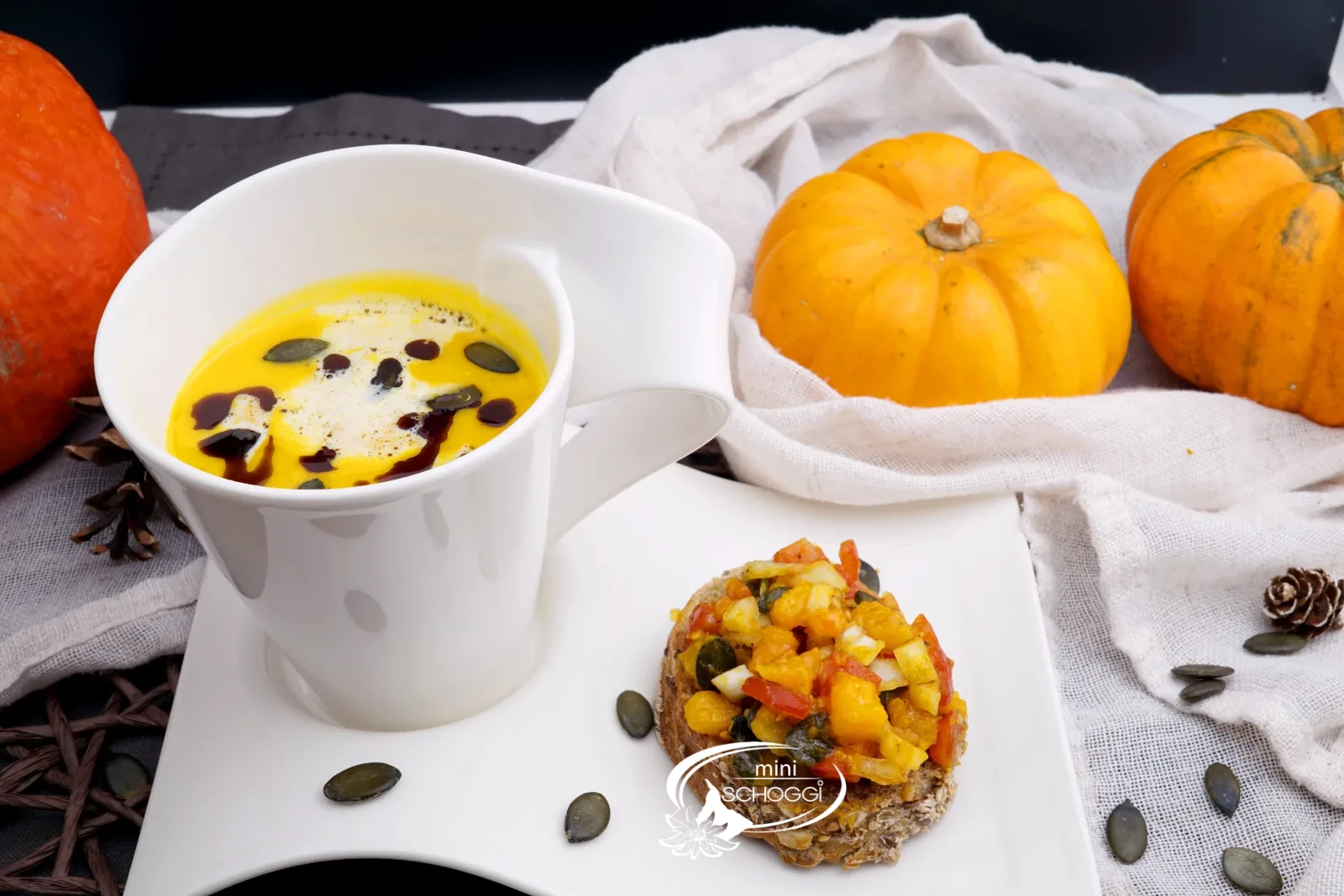 Piatto di vellutata di zucca cremosa con schiuma di latte, olio di semi di zucca e Hüppen