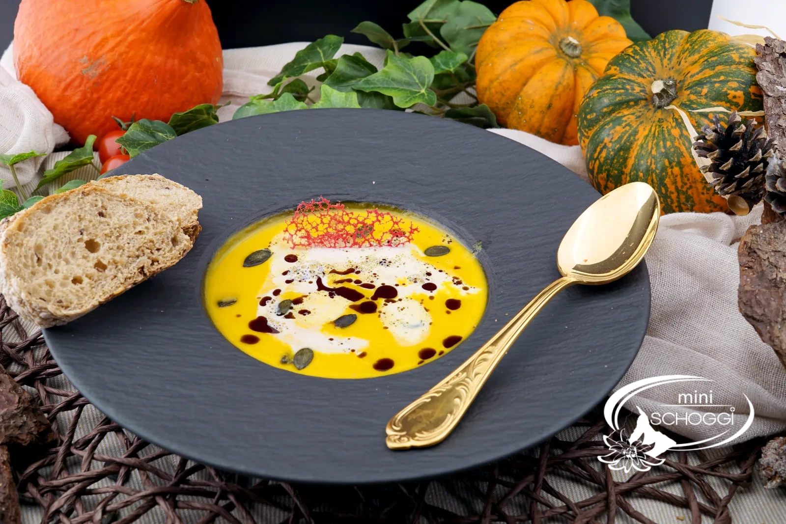 Piatto di vellutata di zucca cremosa con schiuma di latte, olio di semi di zucca e Hüppen