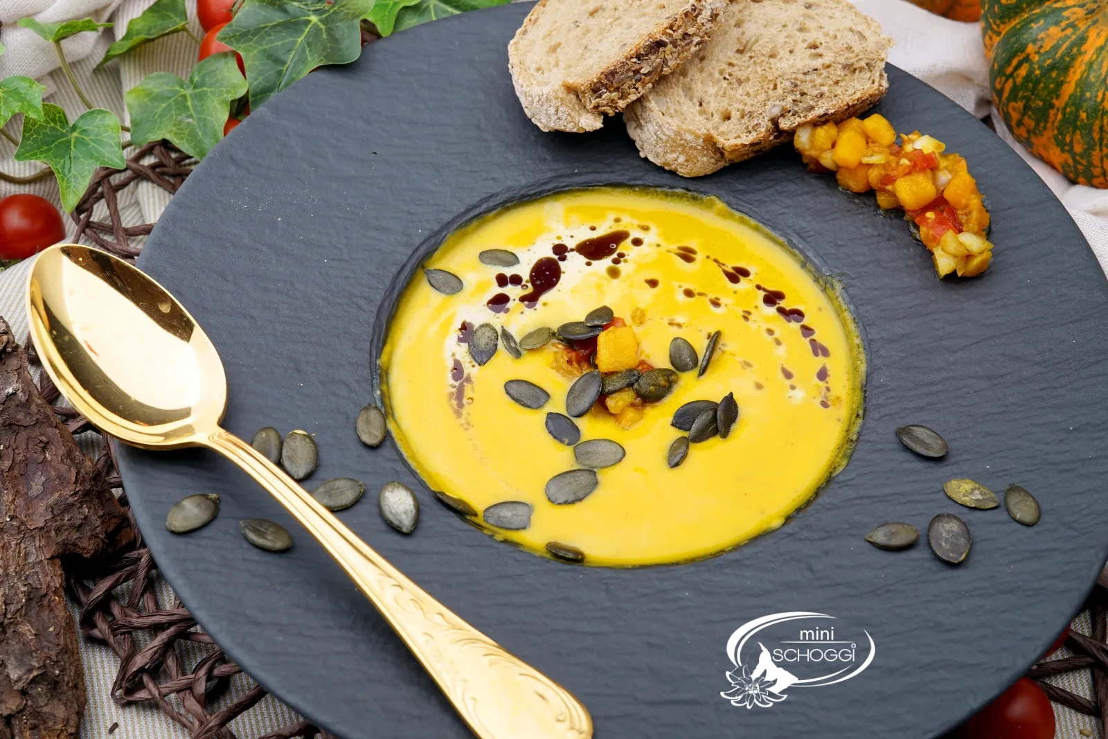 Piatto di vellutata di zucca cremosa con schiuma di latte, olio di semi di zucca e Hüppen
