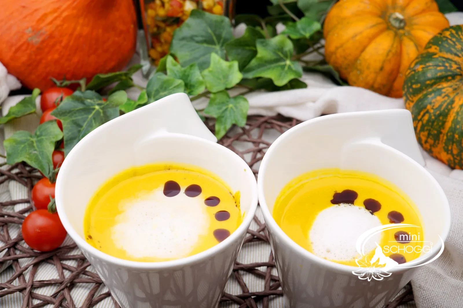 Piatto di cremosa zuppa di zucca con schiuma di latte, olio di semi di zucca e Hüppen