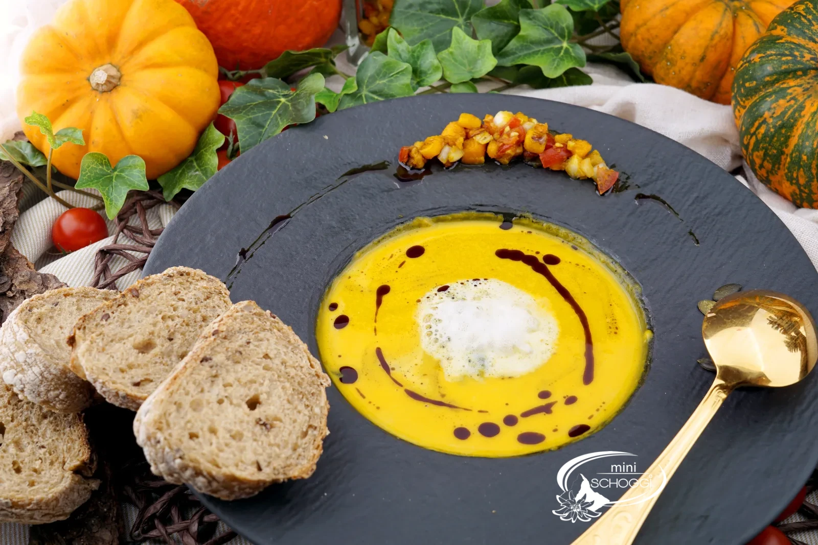 Piatto di vellutata di zucca cremosa con schiuma di latte, olio di semi di zucca e Hüppen