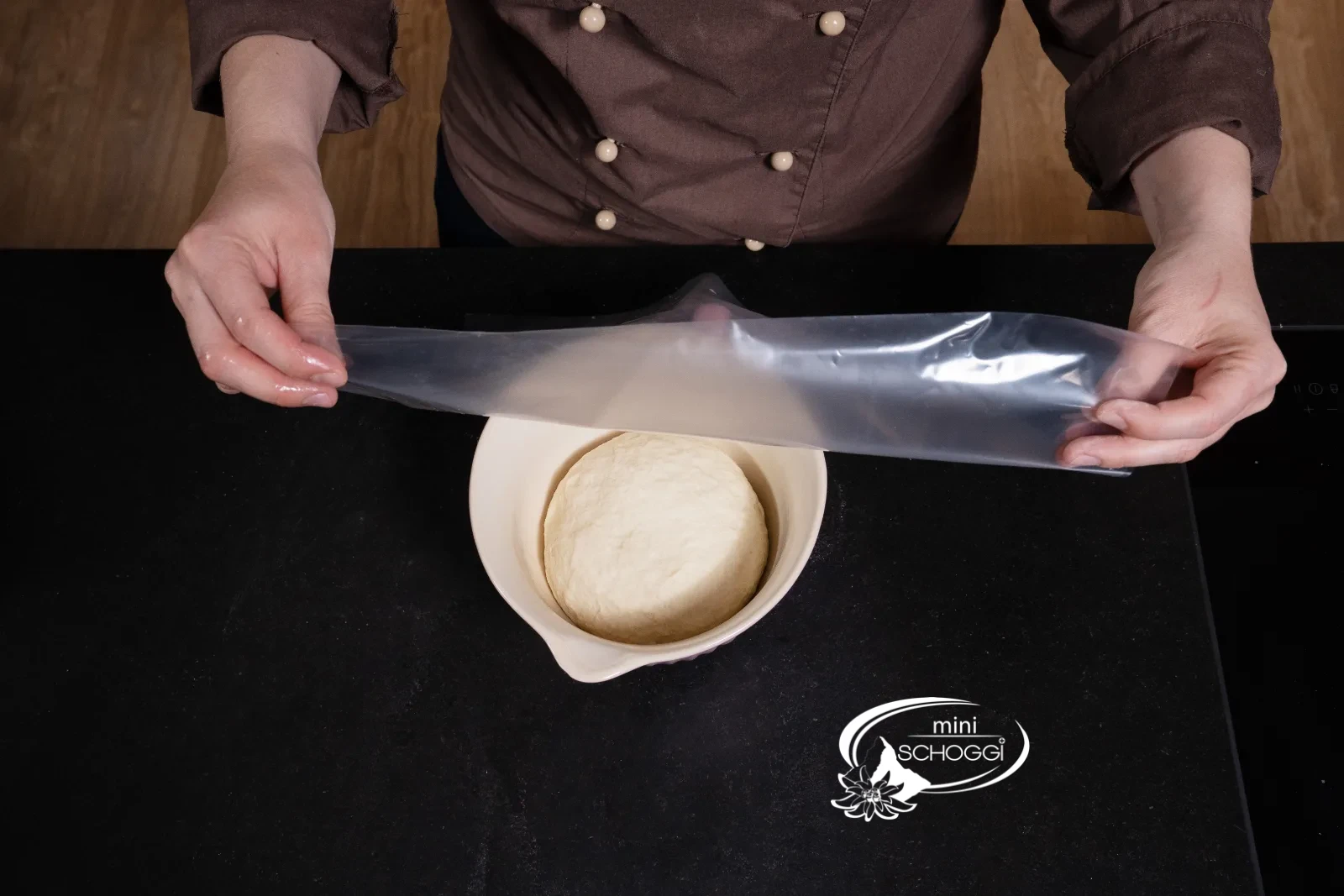 L'impasto riposa coperto con un telo di plastica nella ciotola