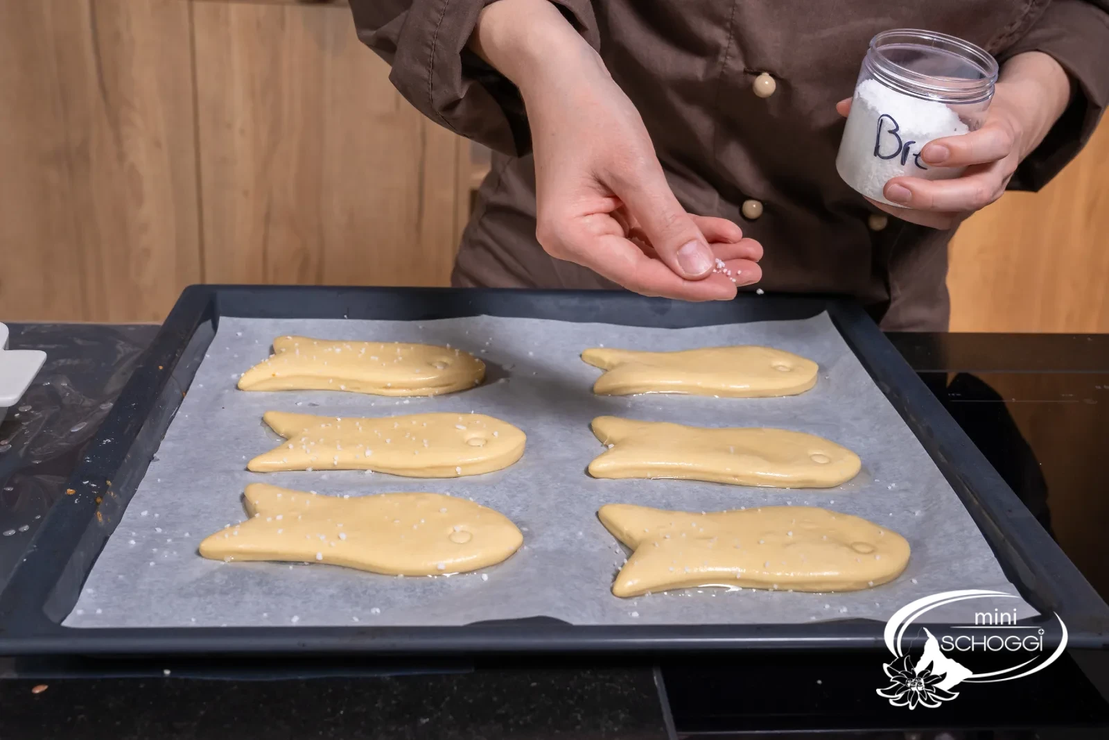 I pesciolini passati nella soluzione alcalina vengono cosparsi di sale per pretzel