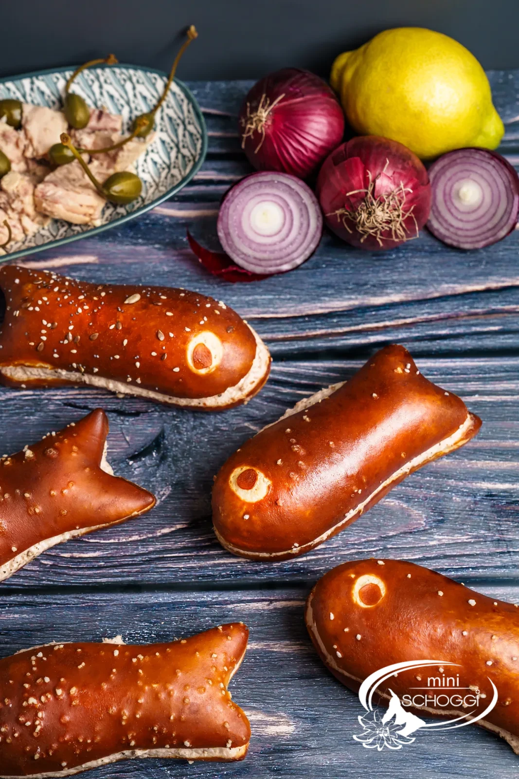 Pesciolini alla soda farciti con mousse di tonno, accanto pomodorini e capperi