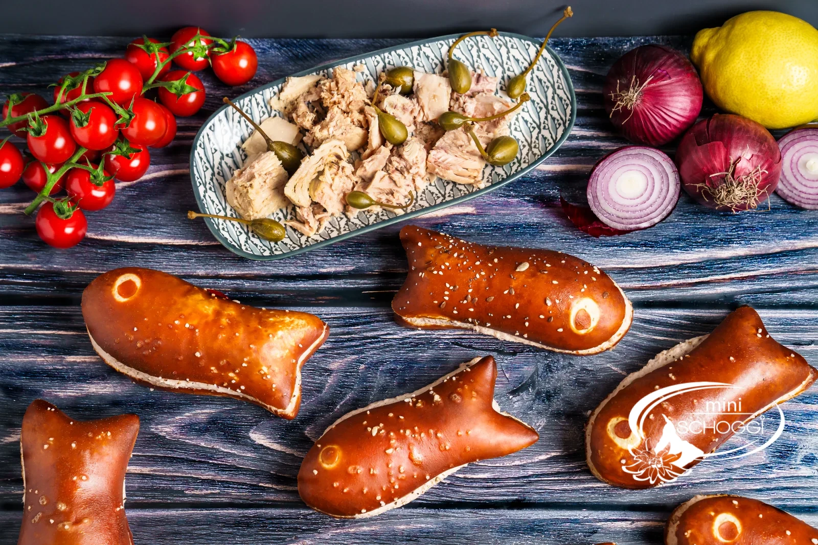 Pesciolini alla soda farciti con mousse di tonno, accanto pomodorini e capperi