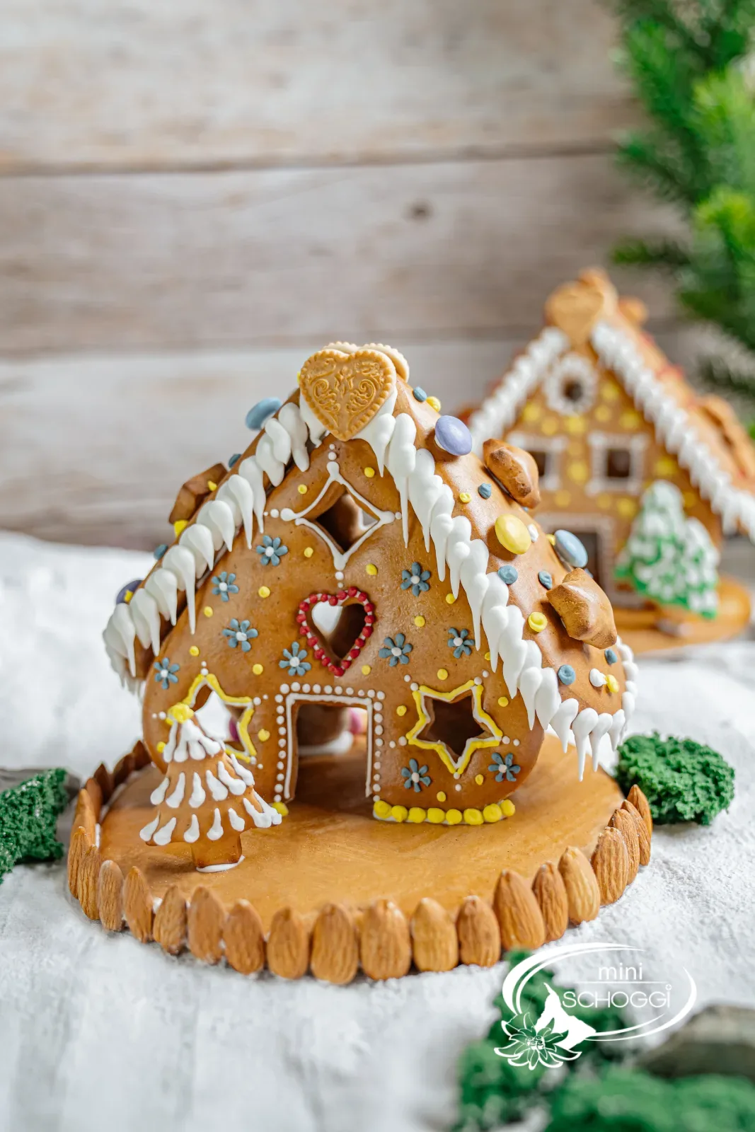 Casa di pan di zenzero decorata con bordo di neve e tetto di mandorle