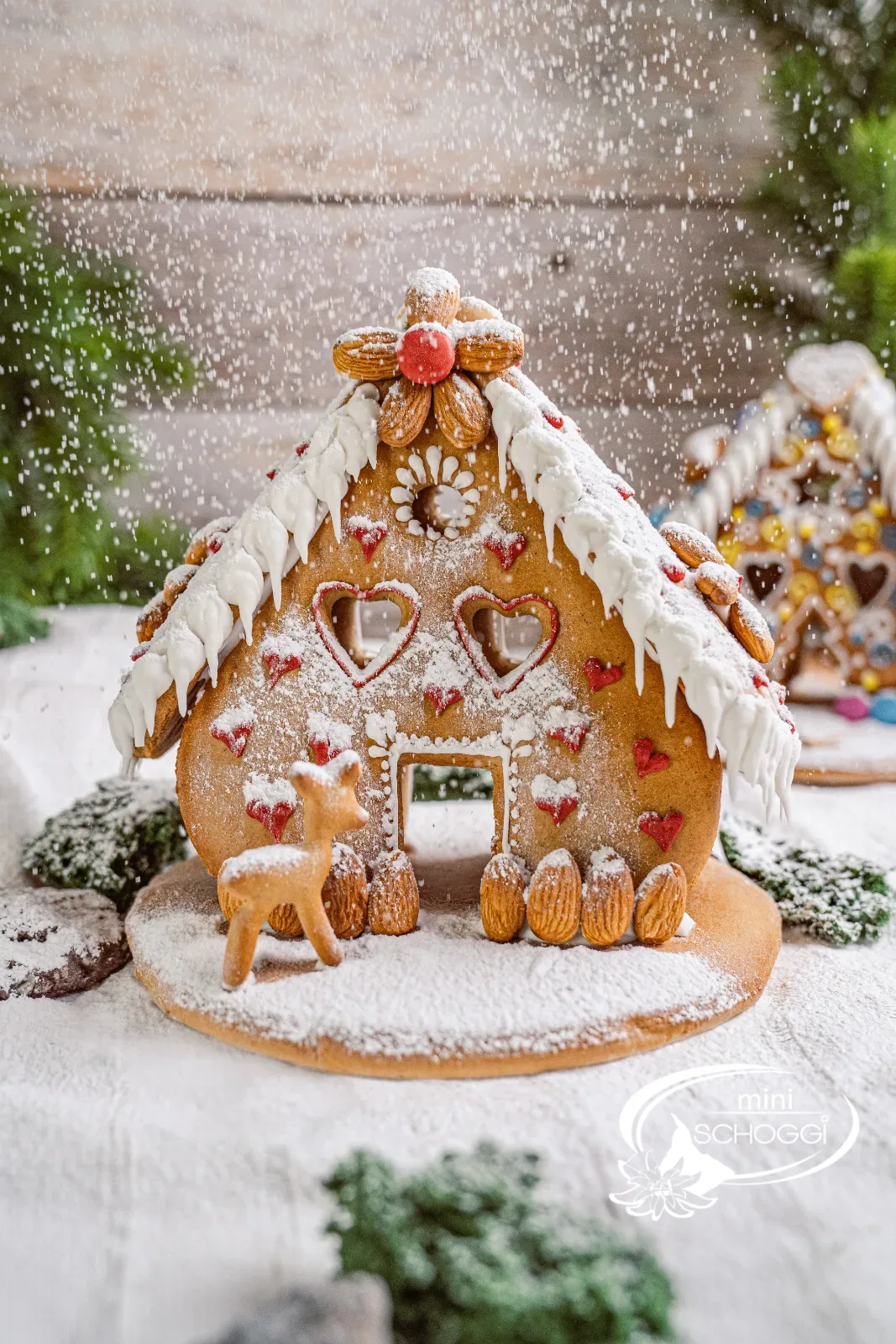 Casa di pan di zenzero decorata con bordo di neve e tetto di mandorle