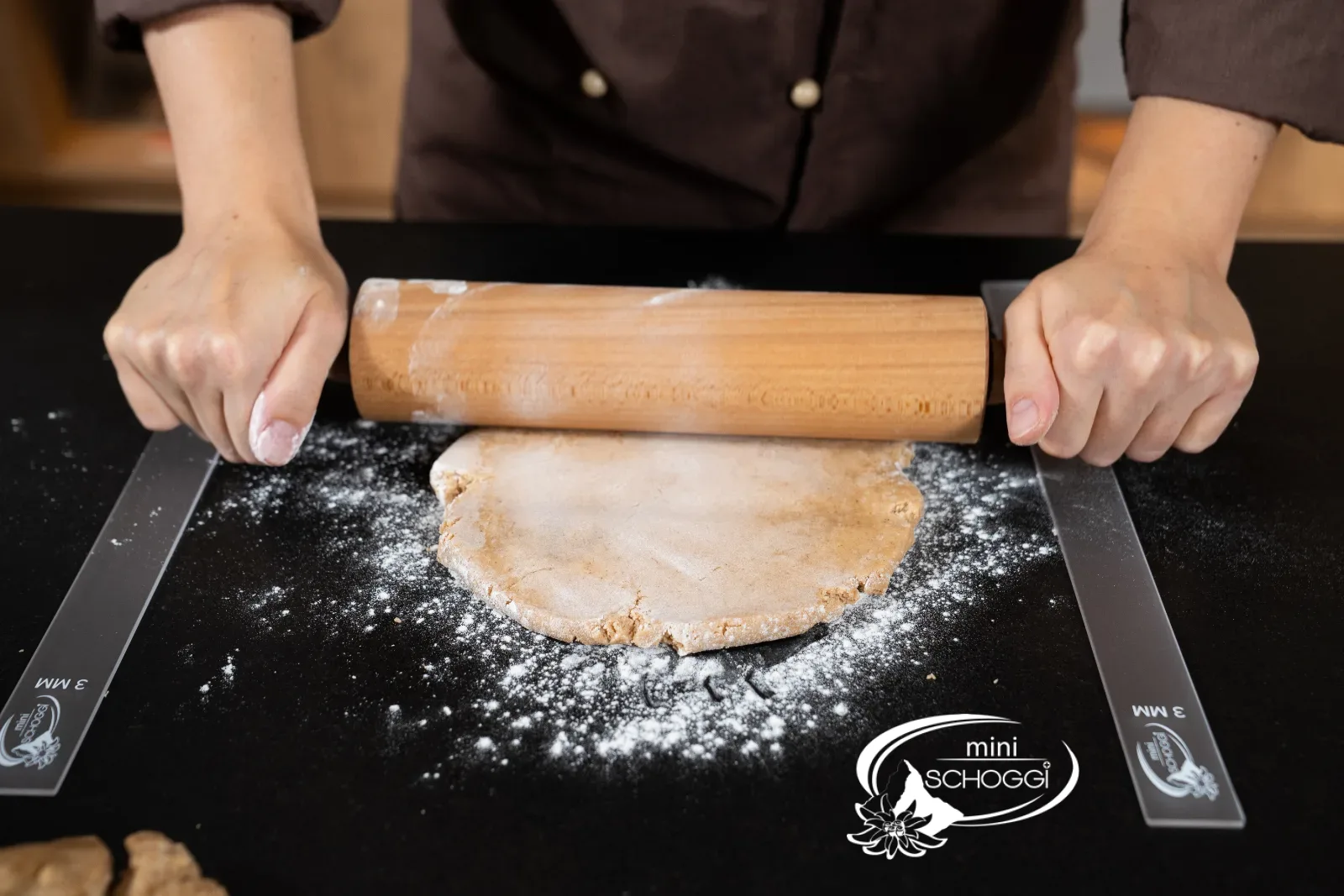 Le guide per stendere a 5 mm sono posate a sinistra e a destra della pasta di pan di zenzero
