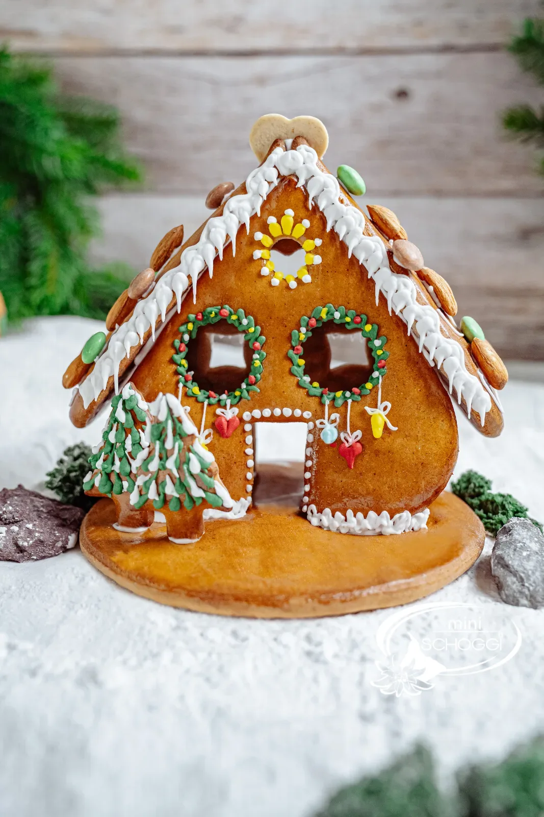 Casa di pan di zenzero decorata con bordo di neve e tetto di mandorle
