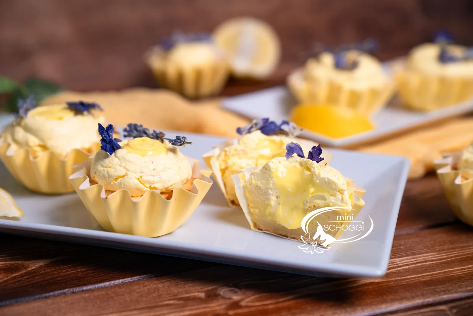 Fertige Lemon Cupcakes mit ganzer Zitrone auf gelbem Tuch