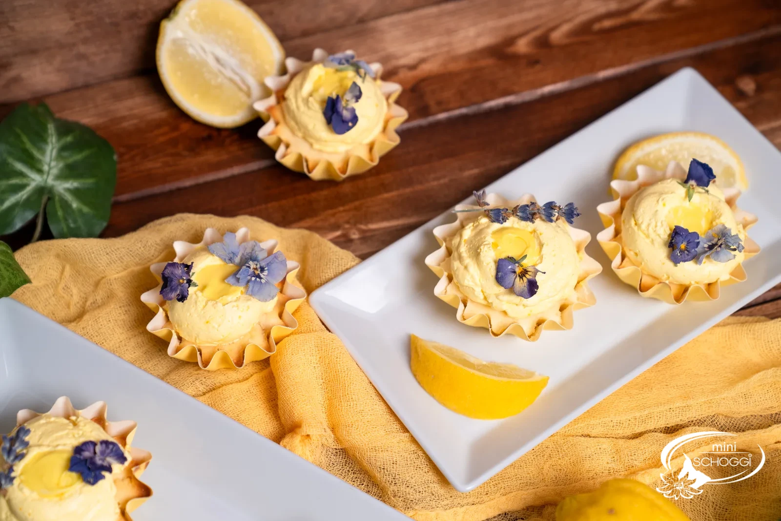 Lemon Cupcakes in gelben Papierförmchen mit Cream Cheese Frosting und Lavendelblüten