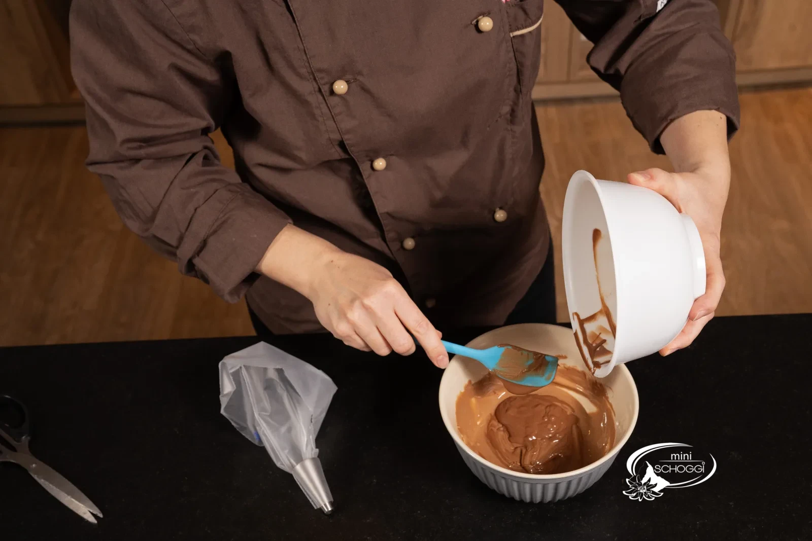 La copertura al latte temperata viene aggiunta alla Gianduja sciolta