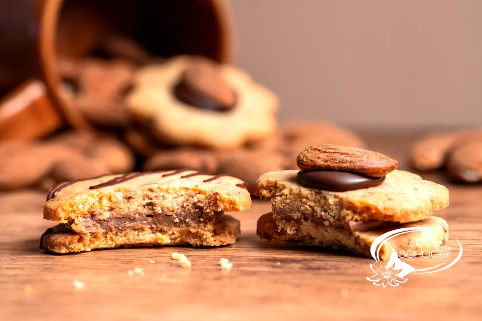 Biscotti con le mandorle impilati con ripieno di Gianduja davanti a una tazza di caffè