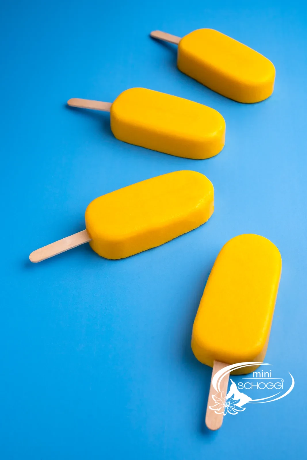 Gelato al mango e yogurt su stecco in primo piano su sfondo blu