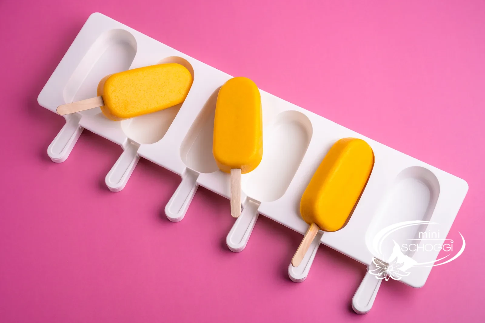 Gelato al mango e yogurt su stecco nello stampo per gelato bianco su sfondo rosa