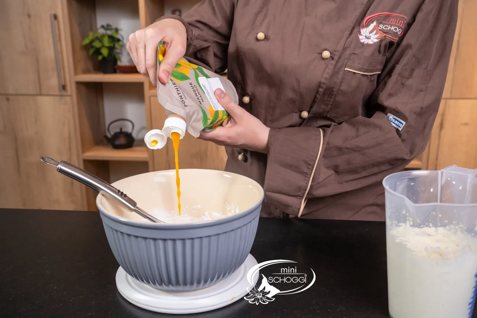 La purea di mango viene versata sulla massa di mascarpone