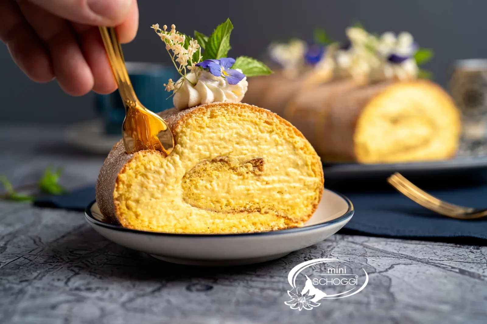 Un pezzo di rotolo con rosetta di panna e fiori tagliato con la forchetta