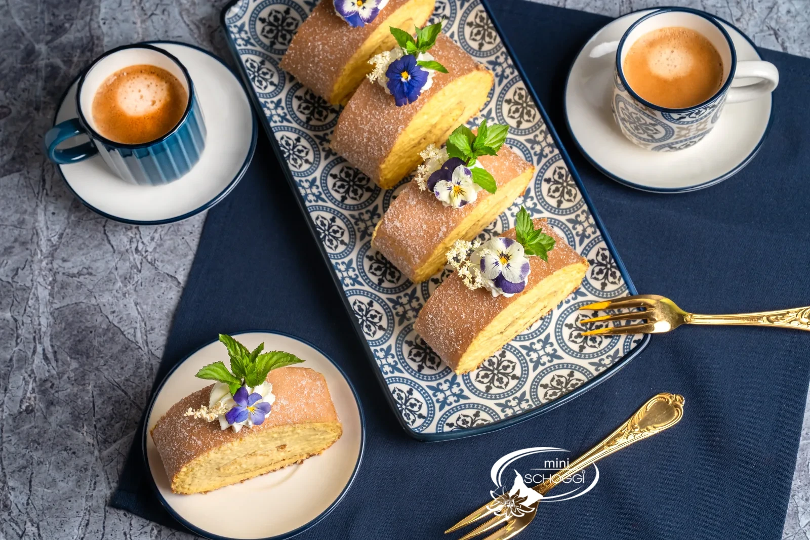 Rotolo al mango e cocco decorato con rosetta di panna, fiori e menta