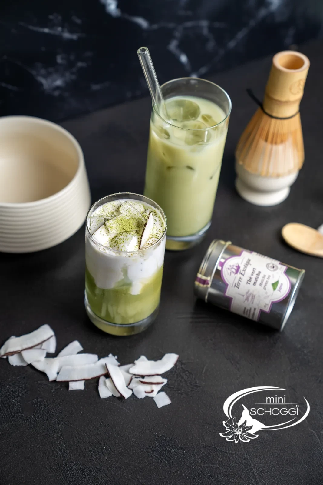 Matcha iced latte in three glasses, with matcha powder on a wooden spoon