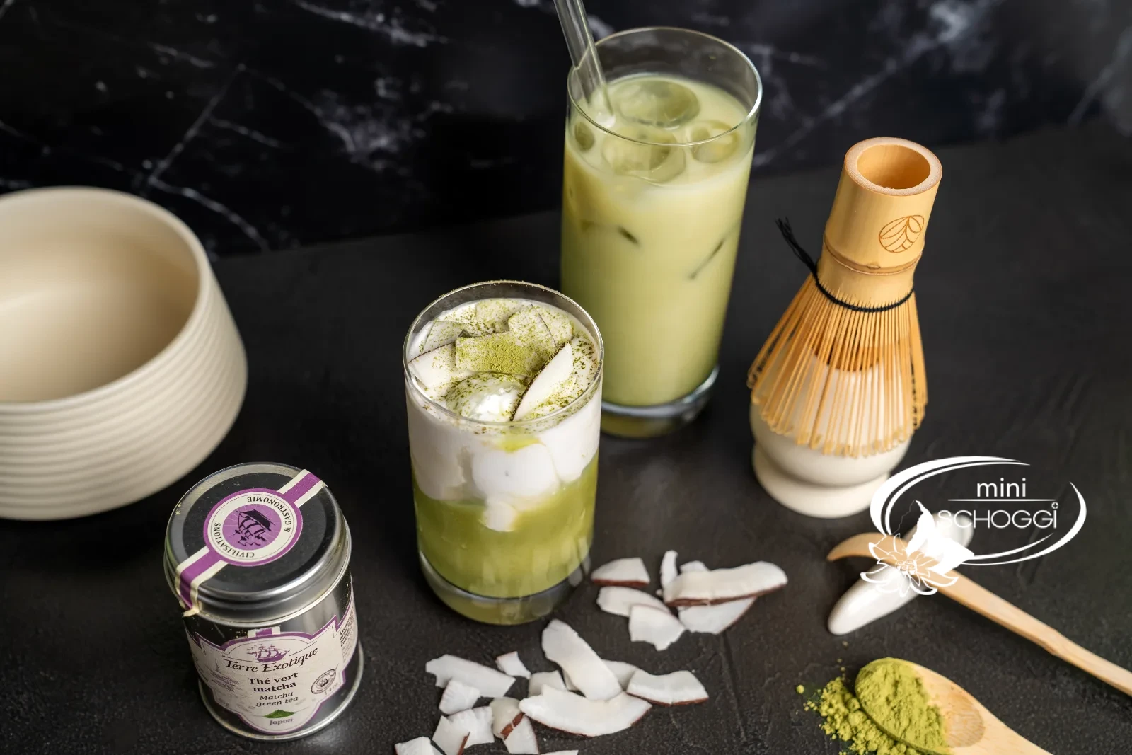 Matcha iced latte in three glasses, with matcha powder on a wooden spoon