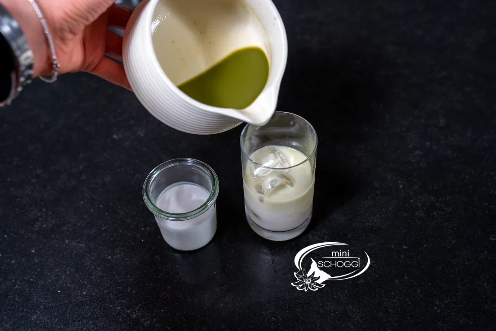 Matcha being slowly poured over the milk into the glass