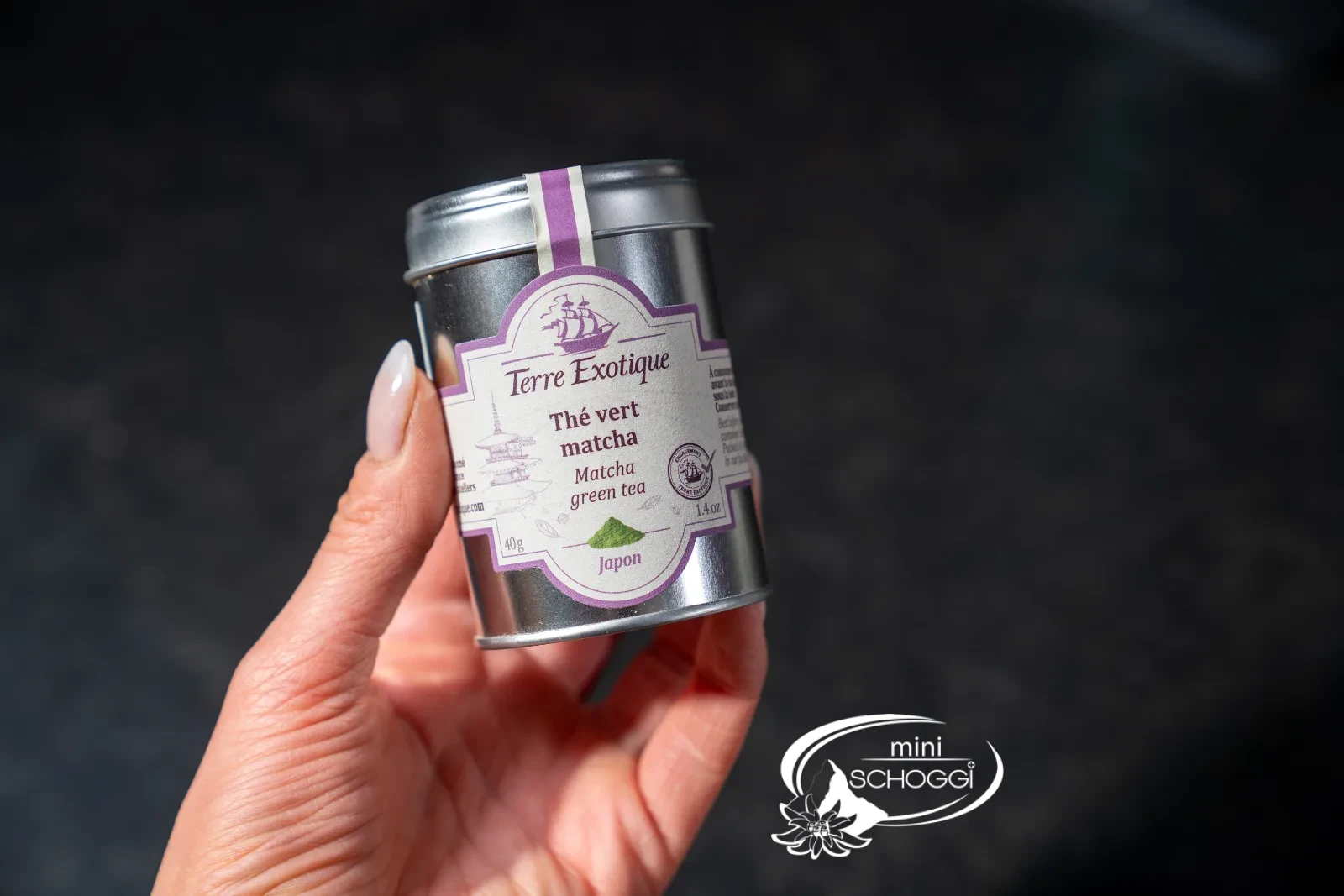 Tin of matcha green tea held in the hand