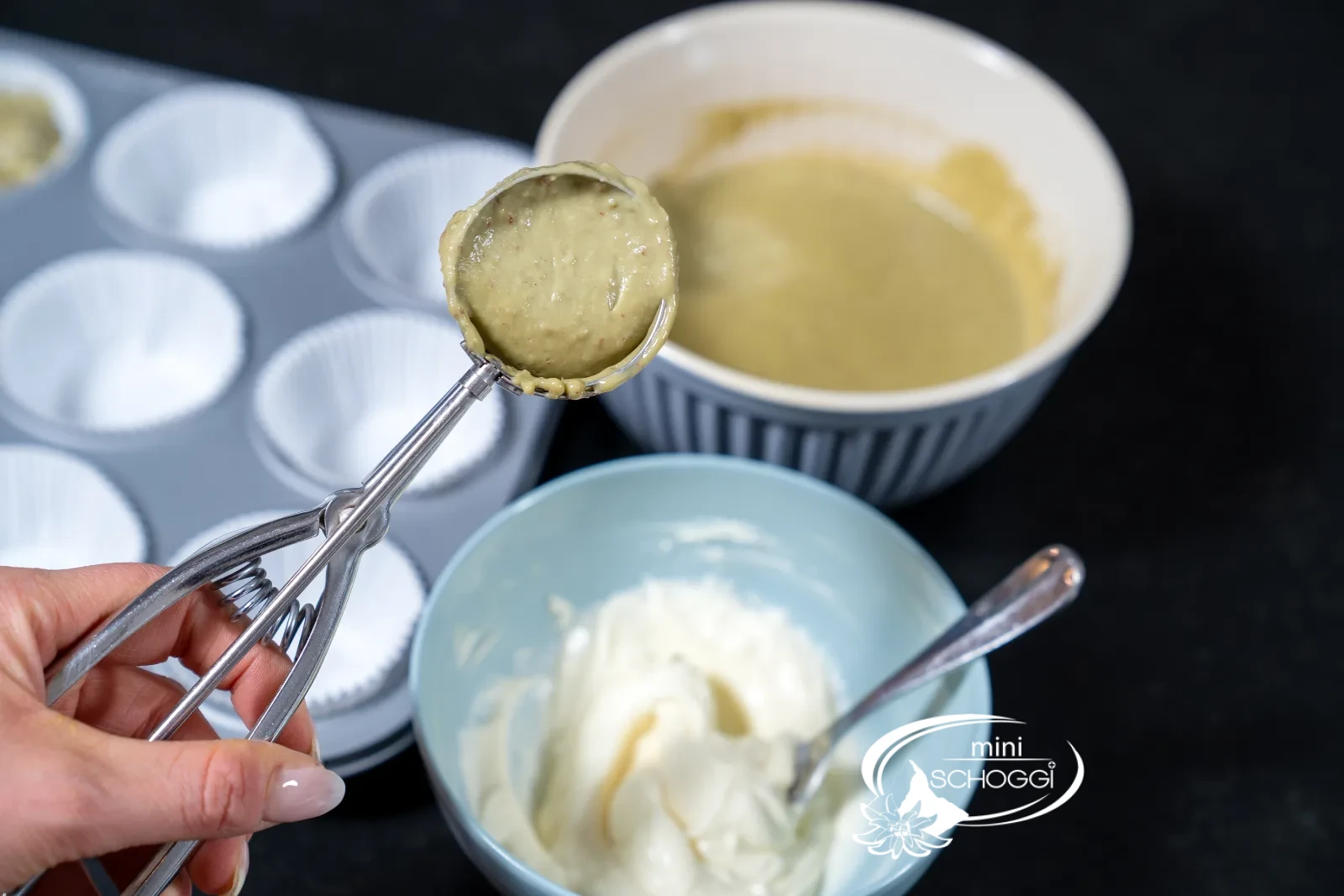 Matcha-Teig wird mit dem Portionierer in die Förmchen gefüllt