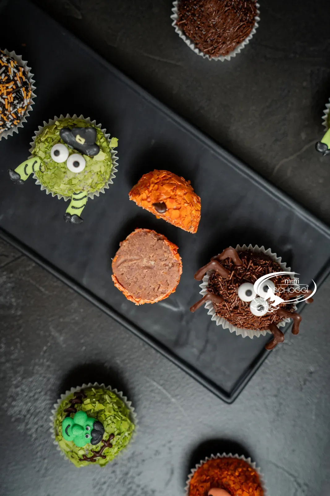 Halbierte Kürbiskugel neben Hexe und Spinne